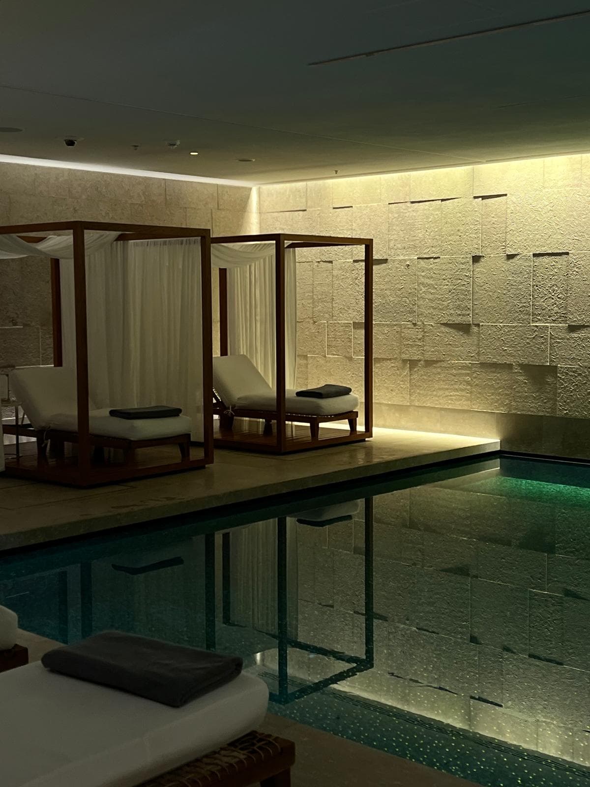 Softly lit indoor pool lined with cabanas